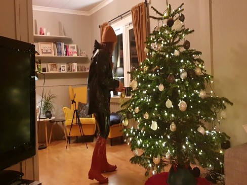 Decorating Christmas tree in rainwear, latex leggings and rubber boots | Porrfilmer.com