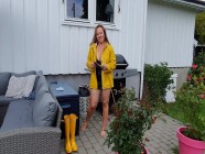 Getting dressed in latex dress, stay ups, raincoat and rubber boots | Porno.nu